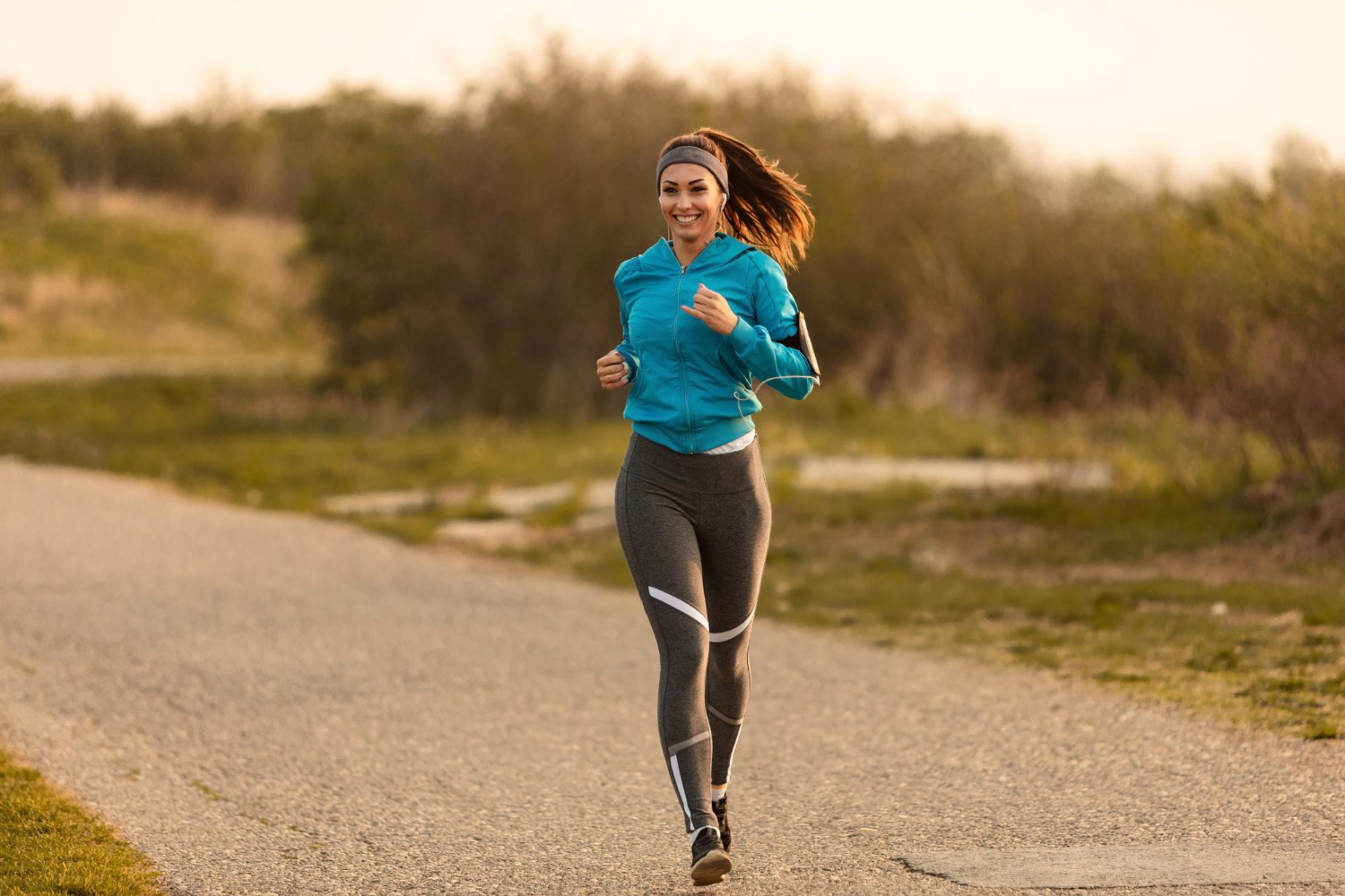young-happy-sportswoman-running-road-morning-copy-space